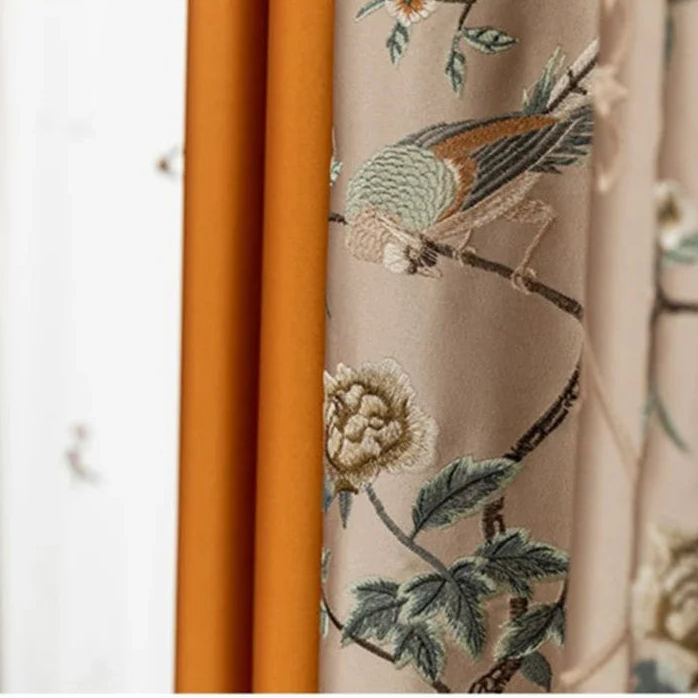 Embroidered fabric with floral and bird design on a beige background